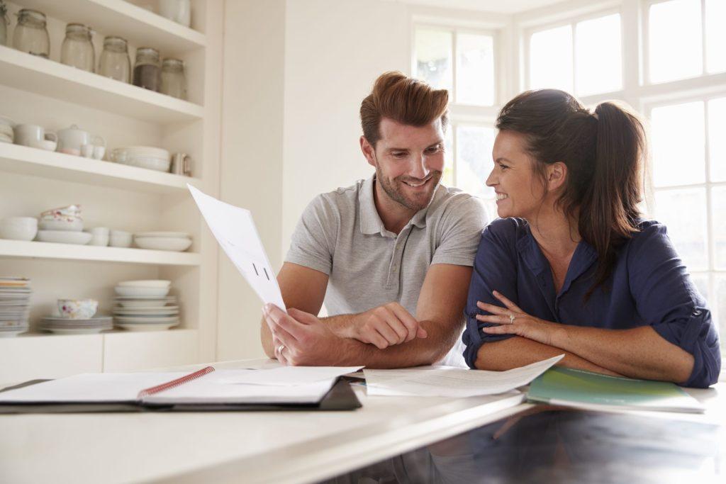 Couple reviewing mortgage paperwork together at home before buying a house in Joplin, MO